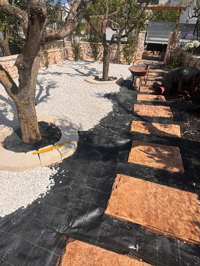 Riqualificazione di un giardino tra gli ulivi: telo pacciamante, ghiaia e lastre in pietra